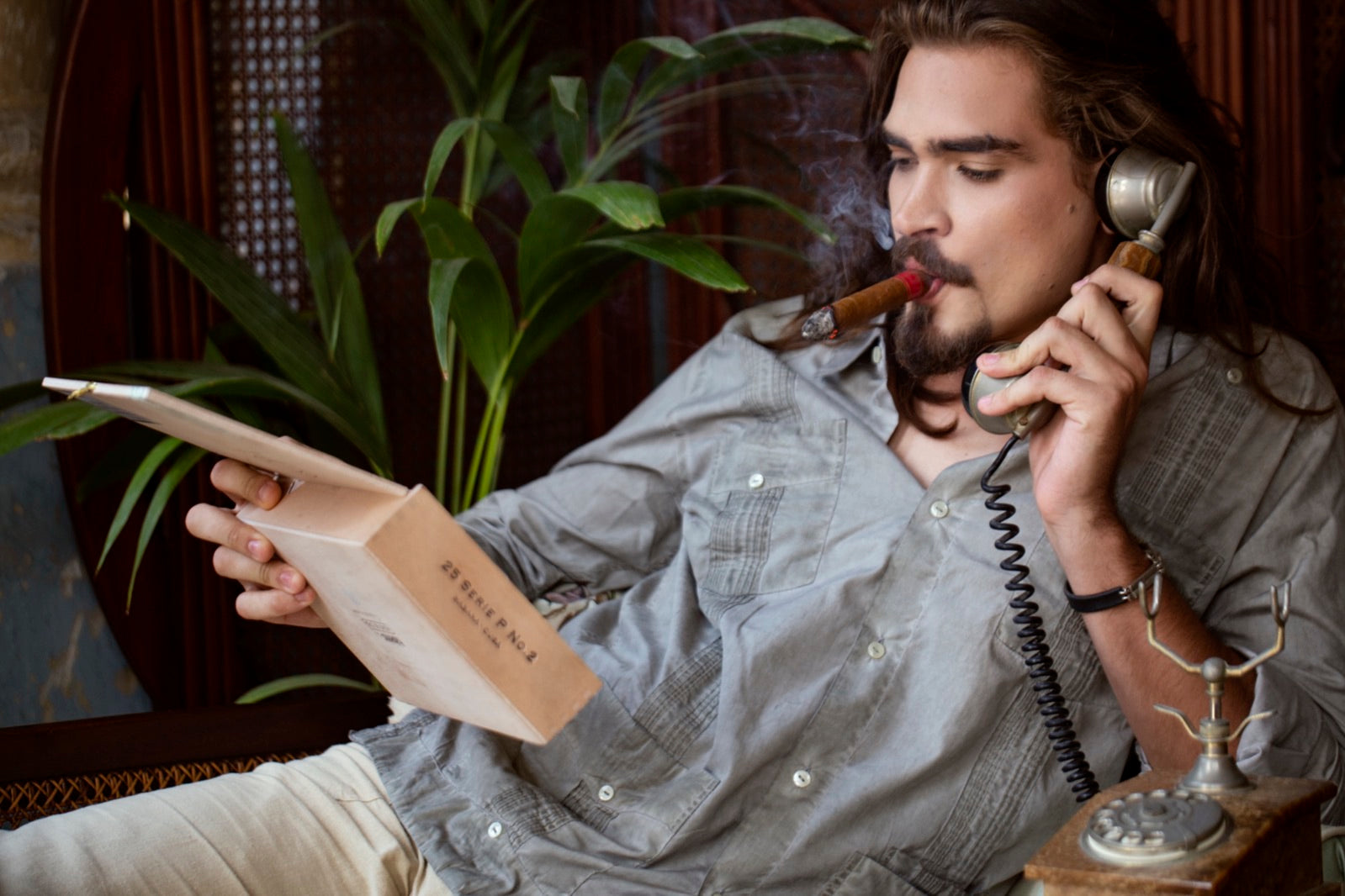 Man relaxing in an elegant lounge enjoying one of the best mild cigars, smoke curling in warm natural light