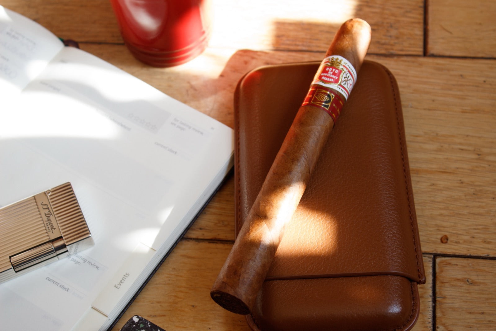 Premium Cuban cigar resting on a glass ashtray with a cutter and spirits in a moody lounge, illustrating common cigar problems like tunnelling and canoeing