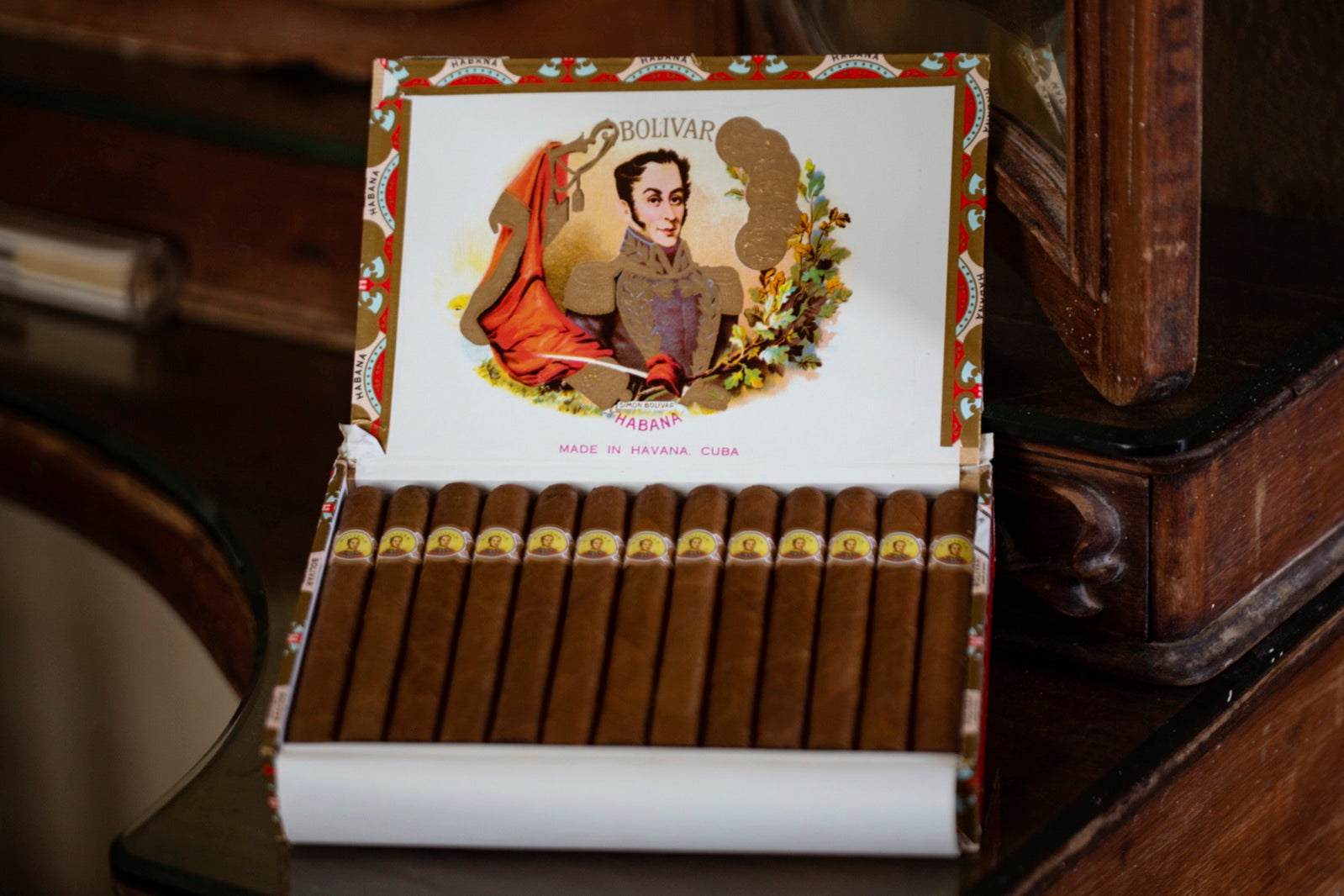 Open box of premium Bolivar Havana cigars on antique wood, an elegant retirement gift idea