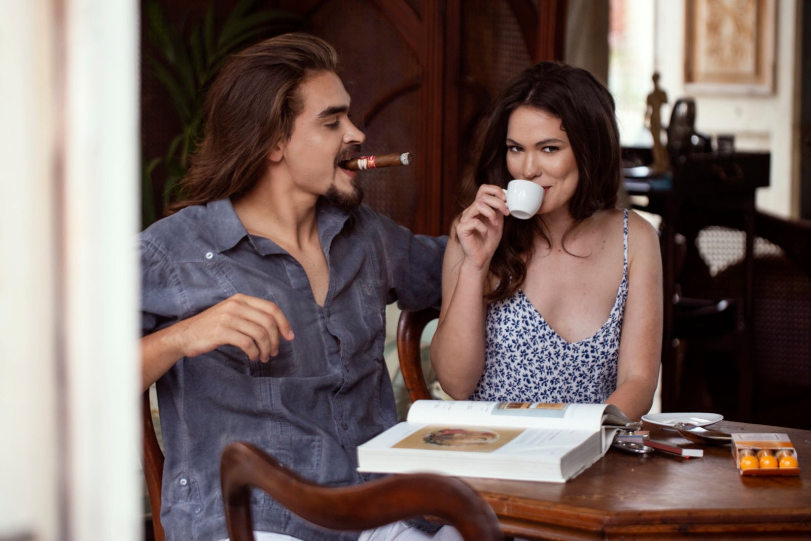 Couple pairing a Havana cigar with espresso coffee at a sunlit table, cigars and coffee after-dinner ritual