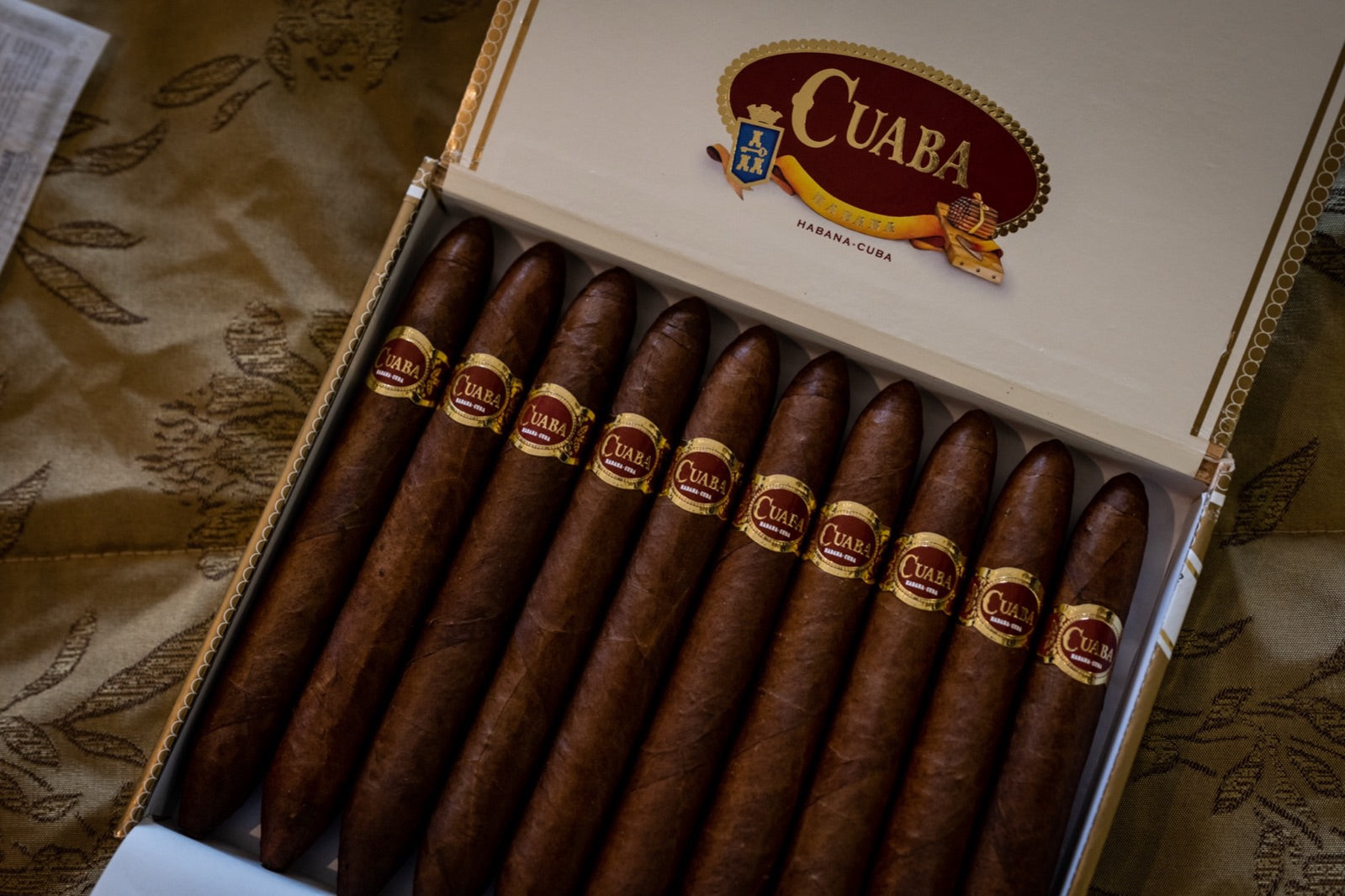 Open Cuaba Havana cigar gift box with hand-rolled banded cigars on damask silk, ideal for cigar samplers and gift sets