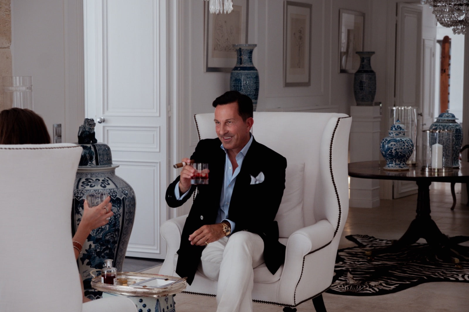 Gentleman relaxing in a grand salon with a glass of whisky and a lit premium Nicaraguan tobacco cigar