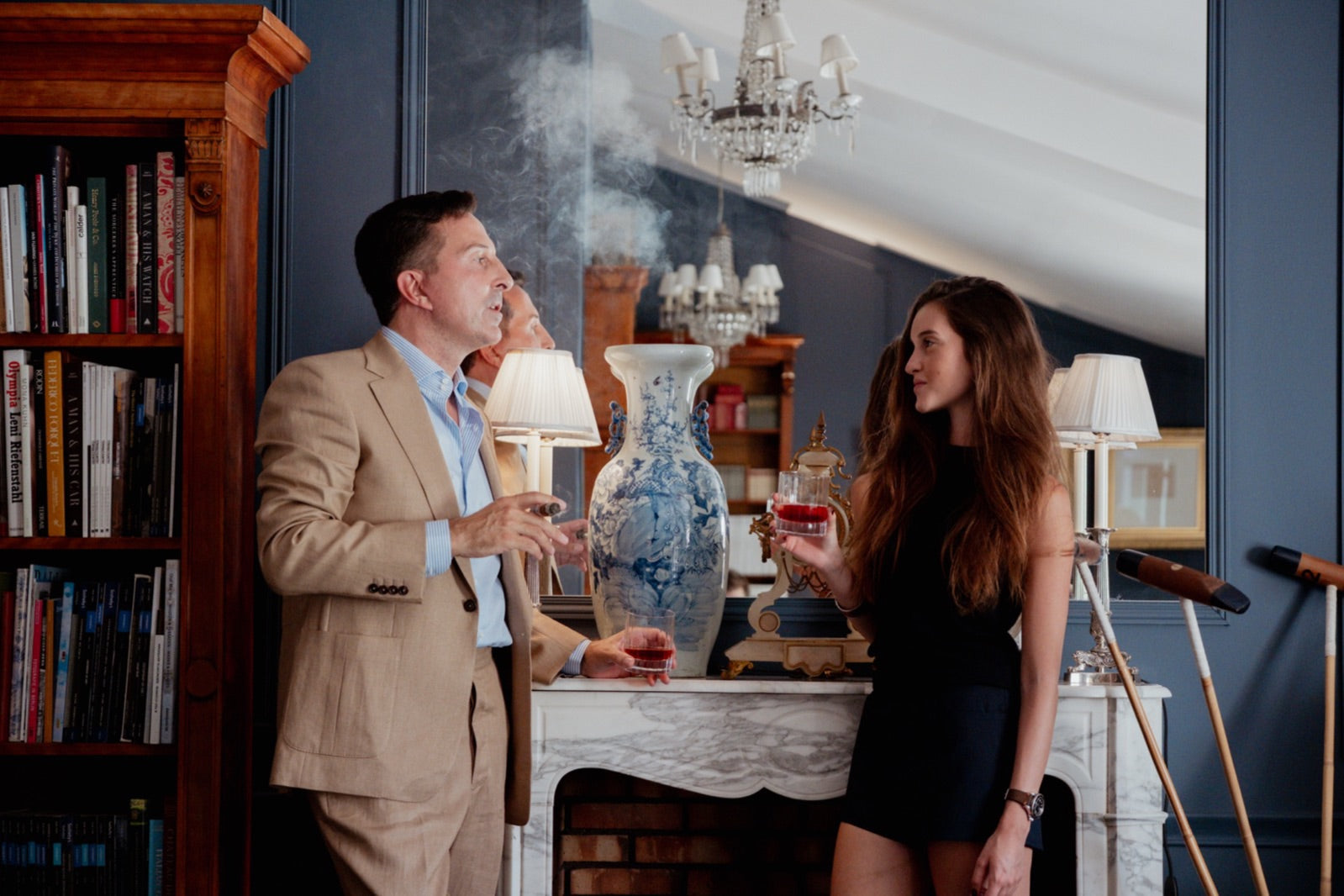 Gentleman exhaling premium cigar smoke in an elegant library lounge, evoking the Perdomo Nicaraguan family empire