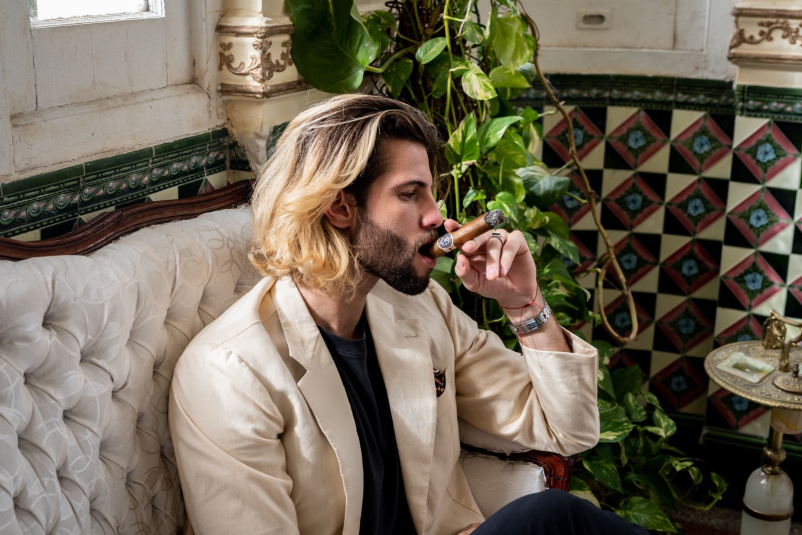 Man enjoying a premium Havana cigar in a colonial Cuban lounge, ideal pairing with tequila and mezcal